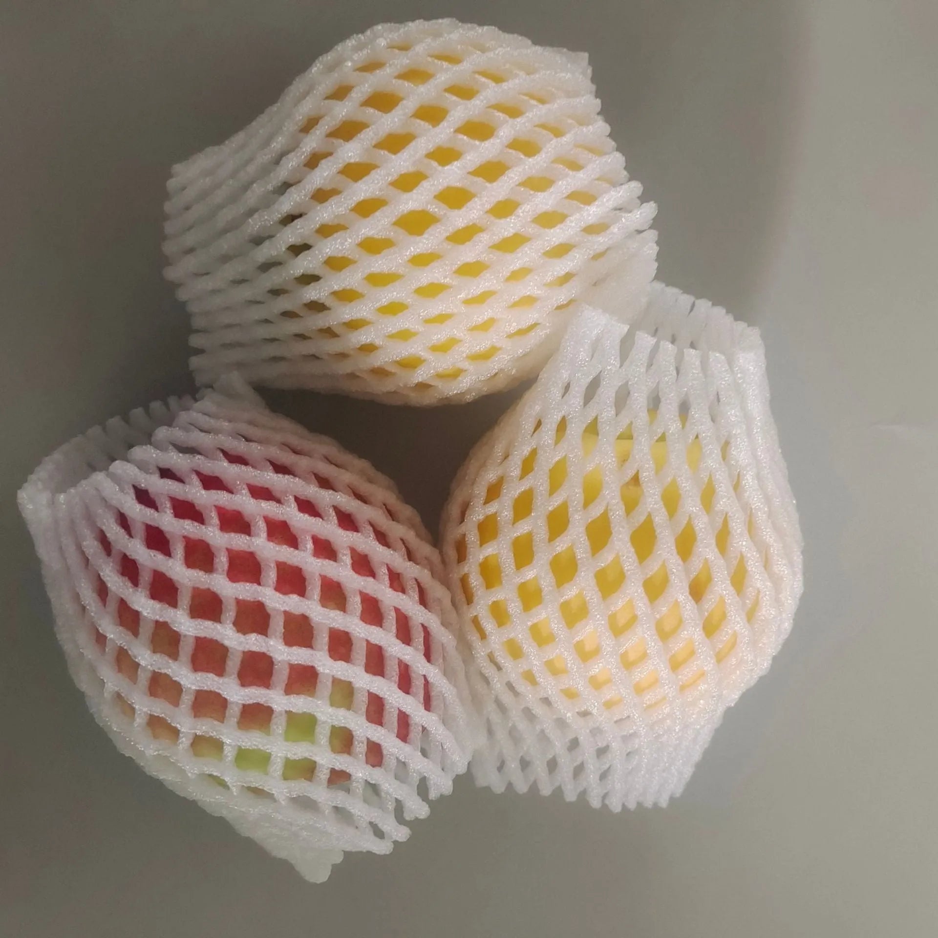 White foam net protective sleeve for apples and oranges, shown in various sizes.