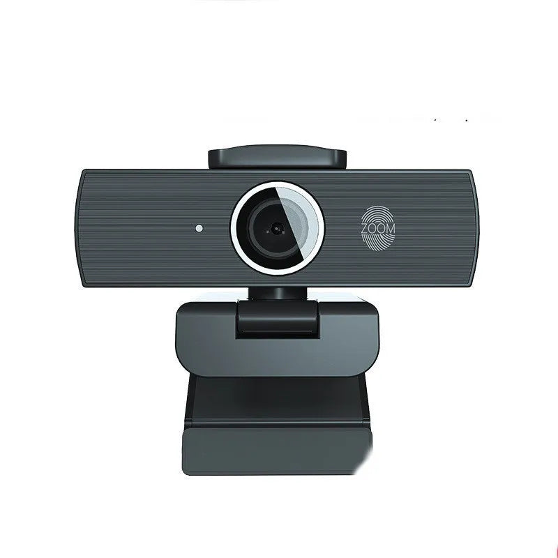 Black computer camera with magnetic privacy cover attached, showing USB cable connection
