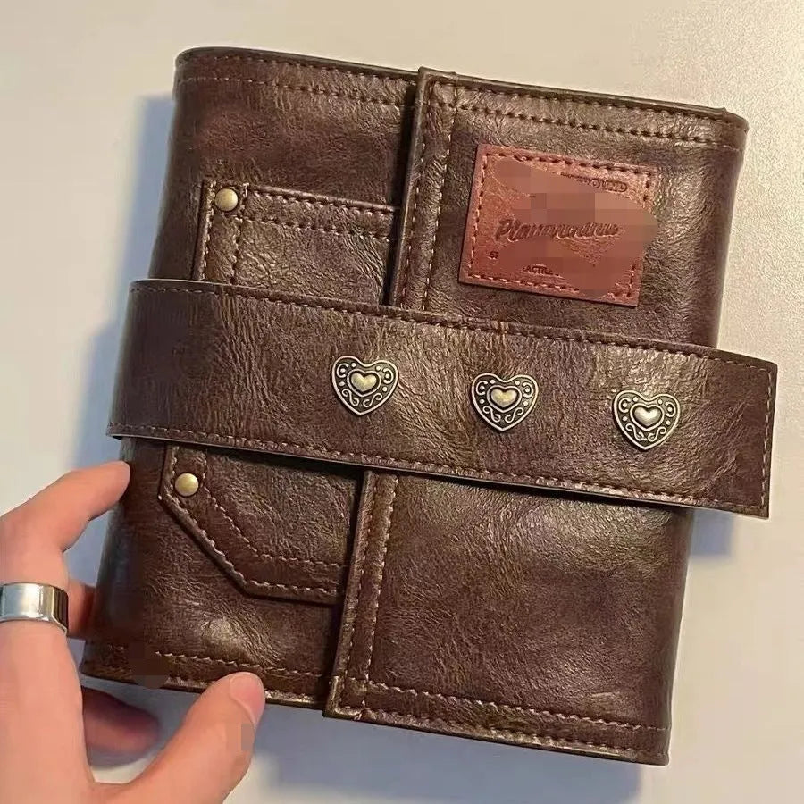 Brown A7 PU leather buckle notebook with loose-leaf binder binding on wooden surface