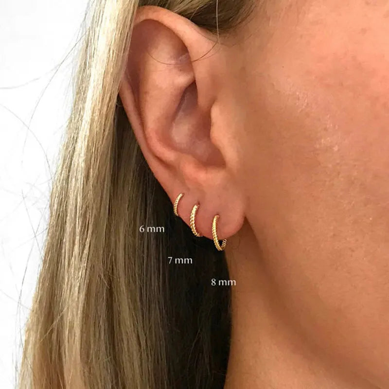 A pair of S925 sterling silver twisted string round hoop earrings on a gold background.