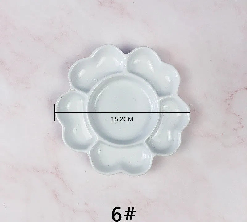 White handmade ceramic plum blossom shaped artist palette for painting.