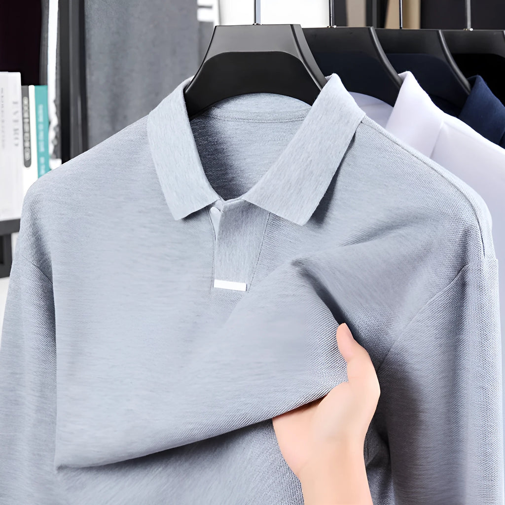 Men's grey cotton polo shirt with lapel collar and asymmetric design, shown in a loose fit.