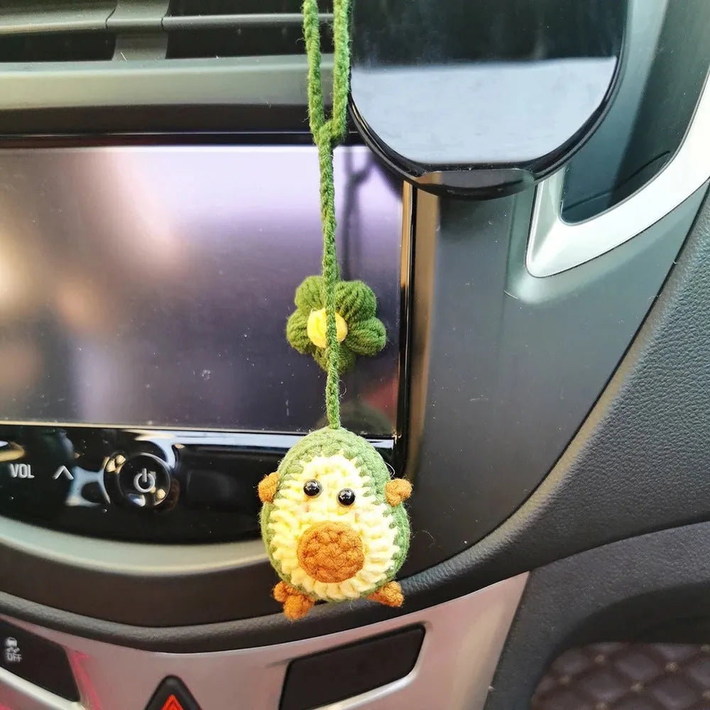 Handmade crocheted avocado-shaped car pendant in wool, shown in three colour variations.