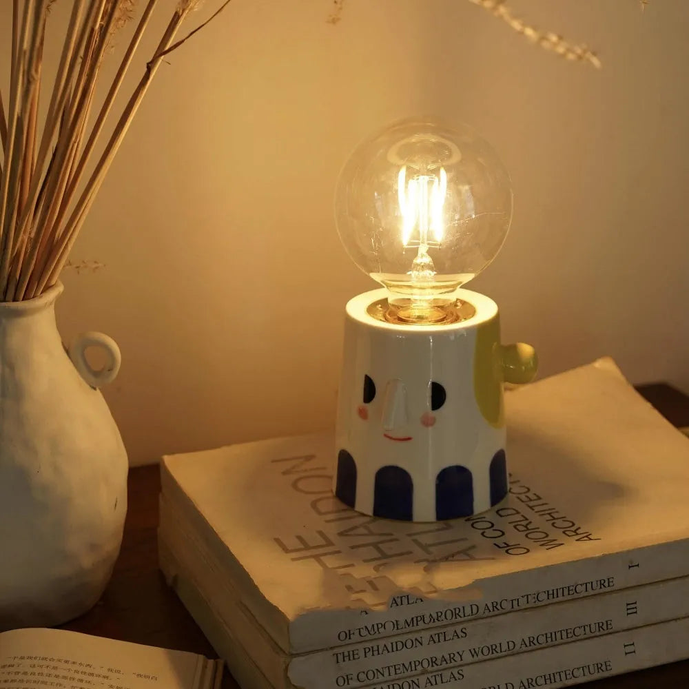 Handmade ceramic bedside lamp with ball headlight design on wooden nightstand