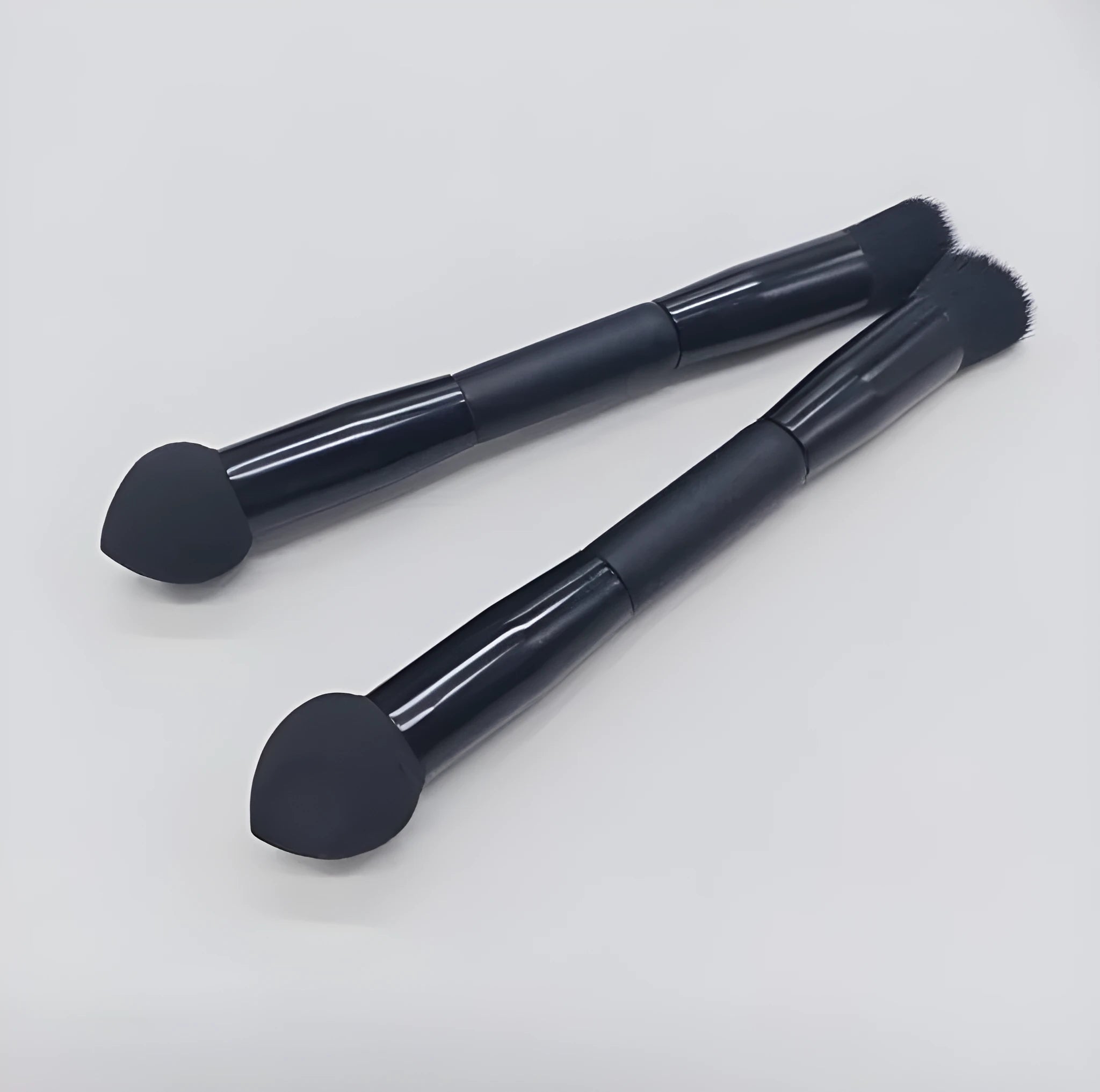 Double-headed makeup brush with black miter sponge and artificial fibre bristles on wooden handle
