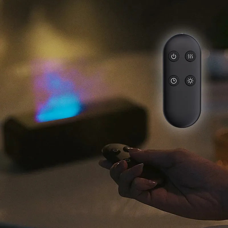 Black and white essential oil diffuser with flame effect and colour-changing lights next to remote control