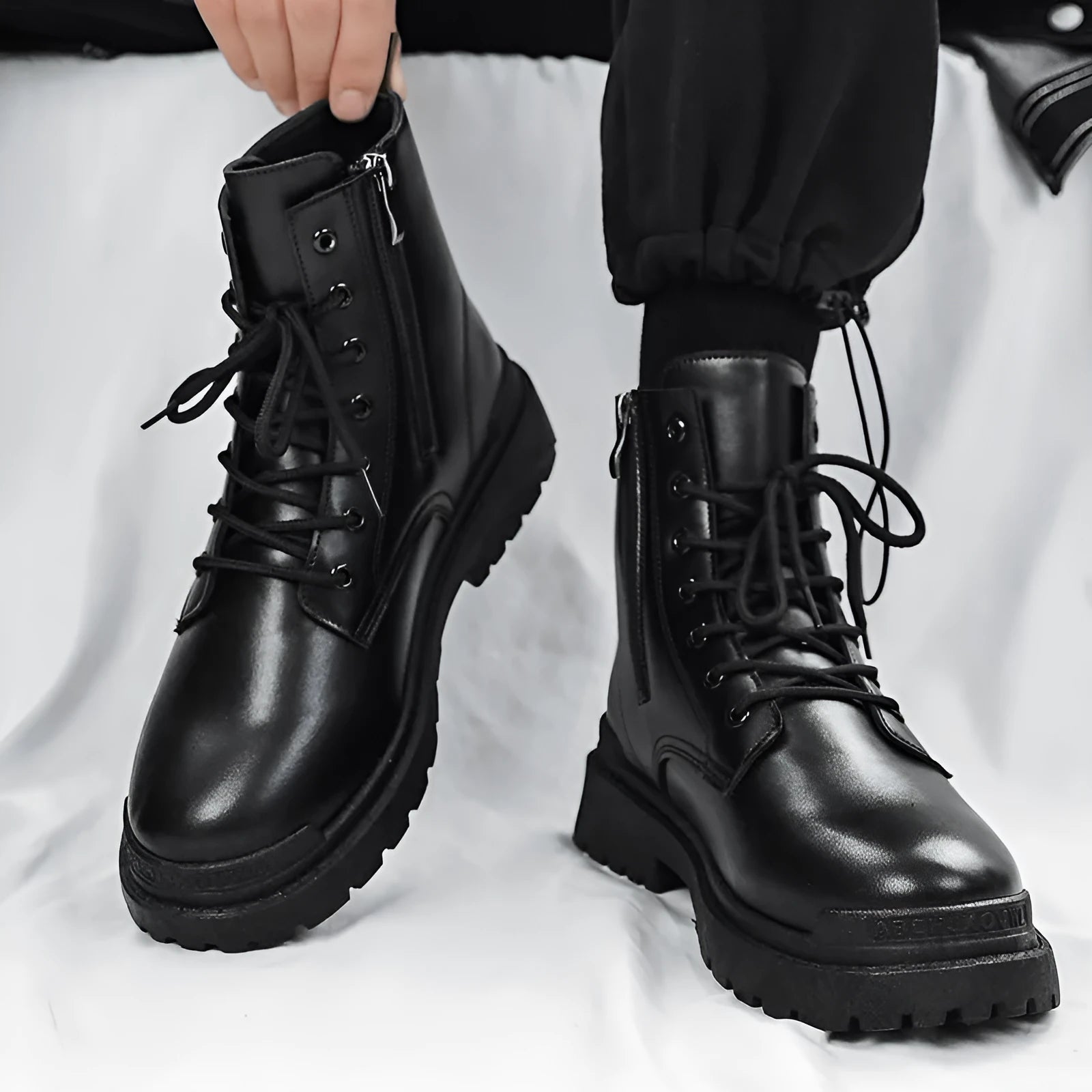 Men's black mid-top leather-style boots with a flat design and rubber sole.