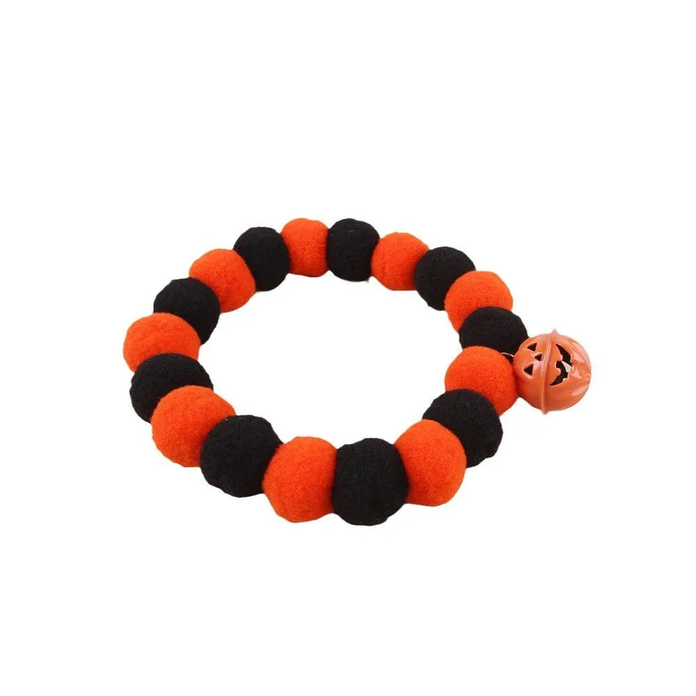 Halloween pet collar with orange pumpkin charm on black and white patterned nylon strap.
