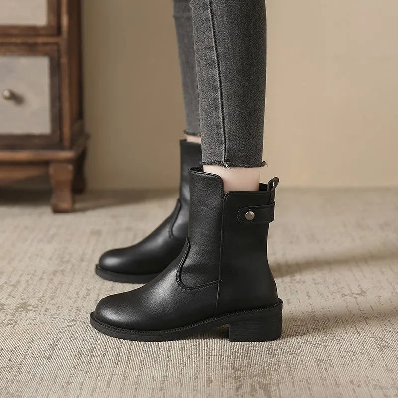 Black women's low heel ankle boots with a side zip and round toe on a rubber sole.