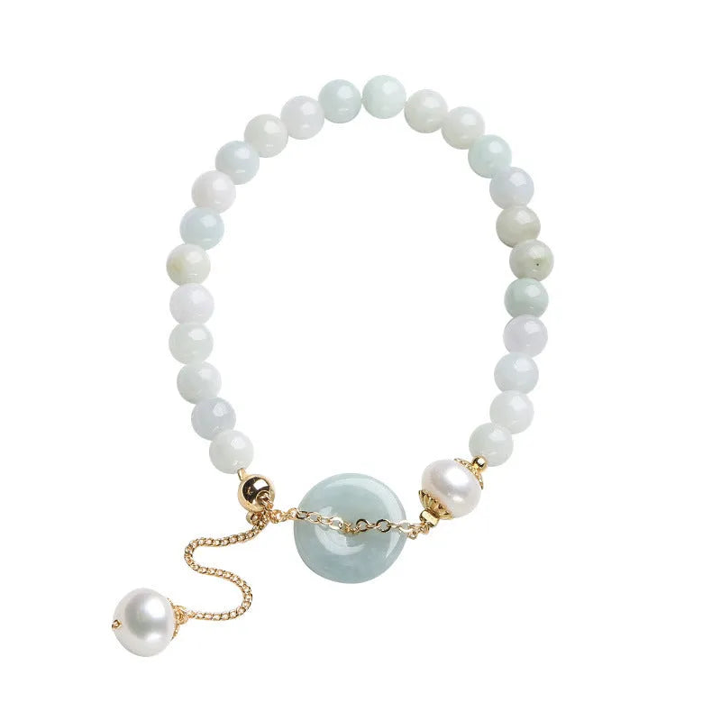 Natural green jade and pearl bracelet with peace buckle closure on wrist