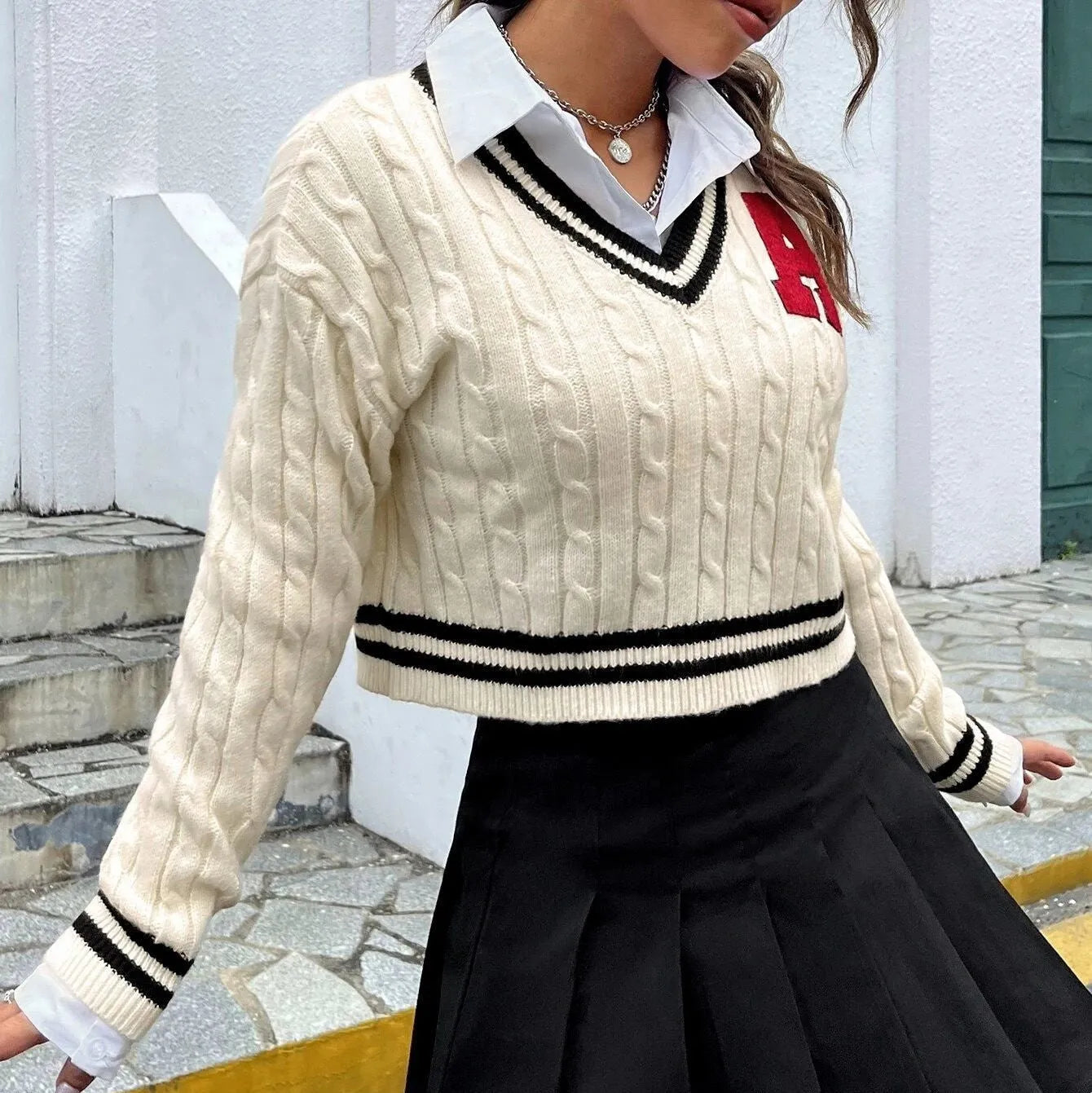 V-neck creamy white knitted shirt with slim stripes and patch detail on model