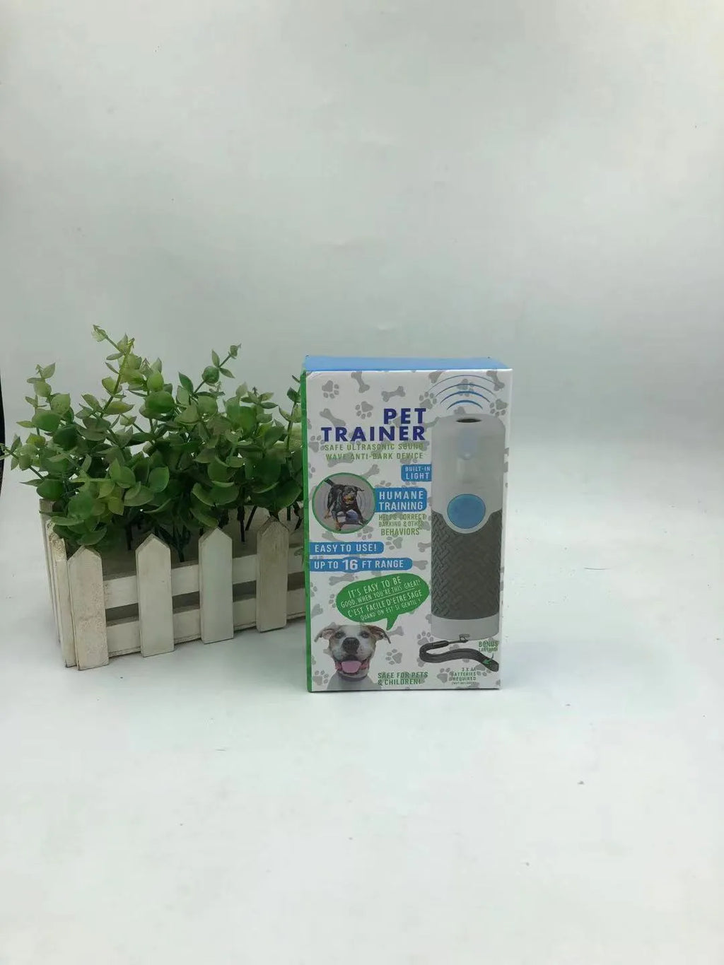 White handheld ultrasonic dog bark control trainer with AAA battery compartment.