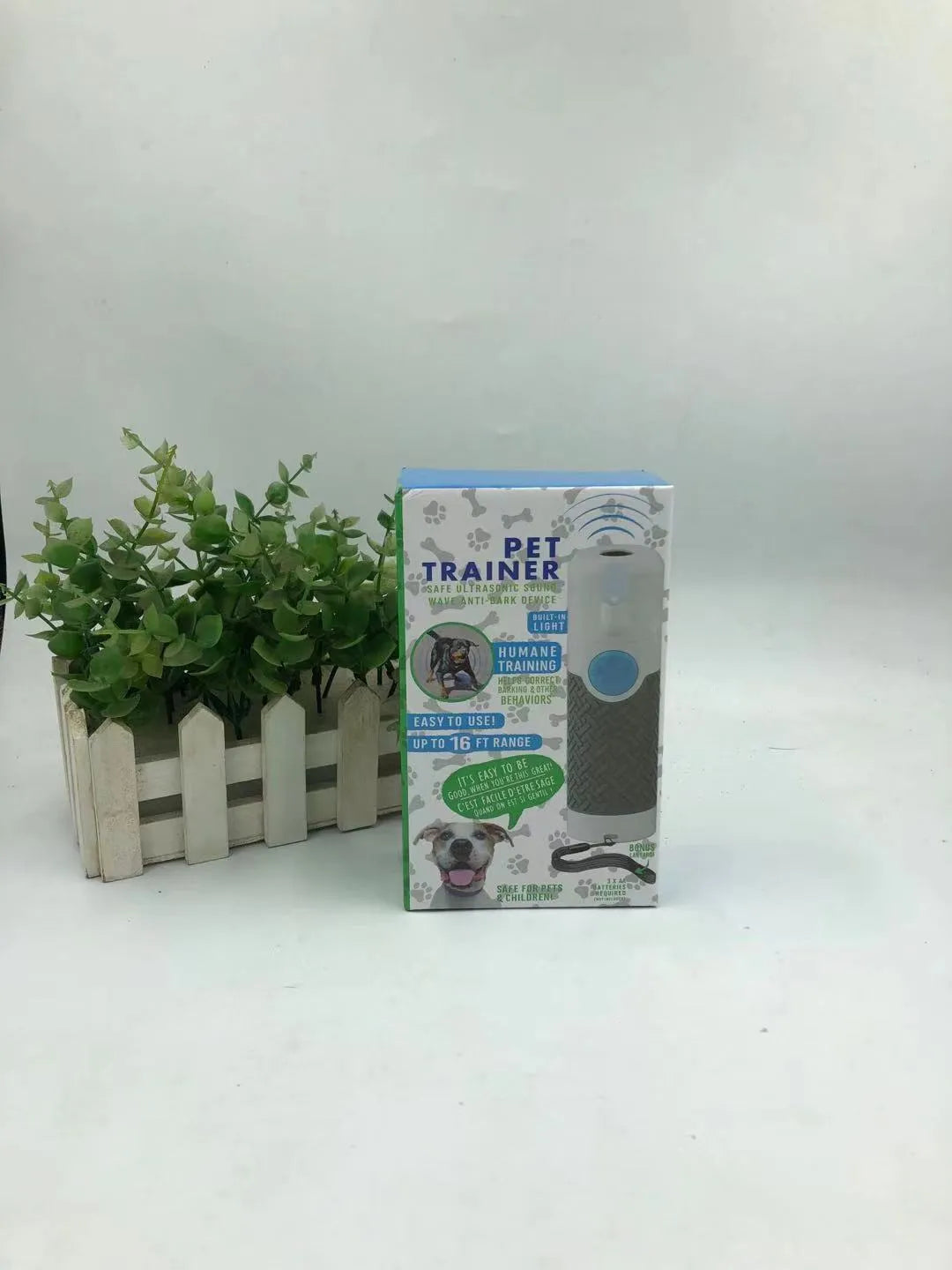 White handheld ultrasonic dog bark control trainer with AAA battery compartment.