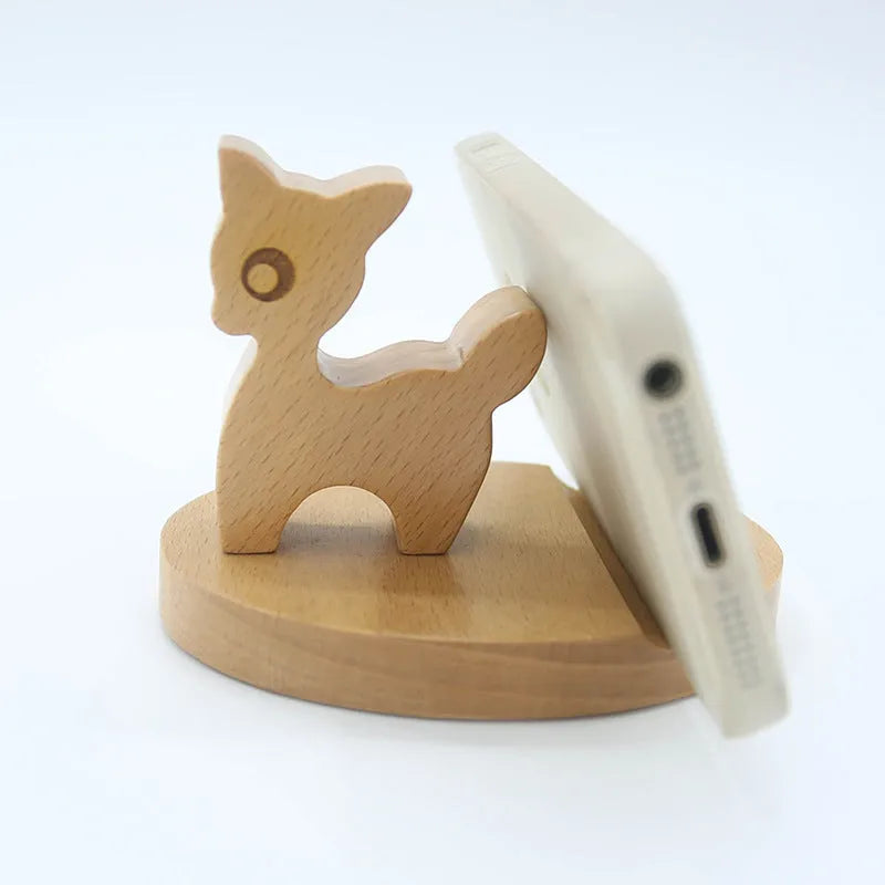 Resin decorative mobile phone holder bracket in an animal design on a wooden desk.