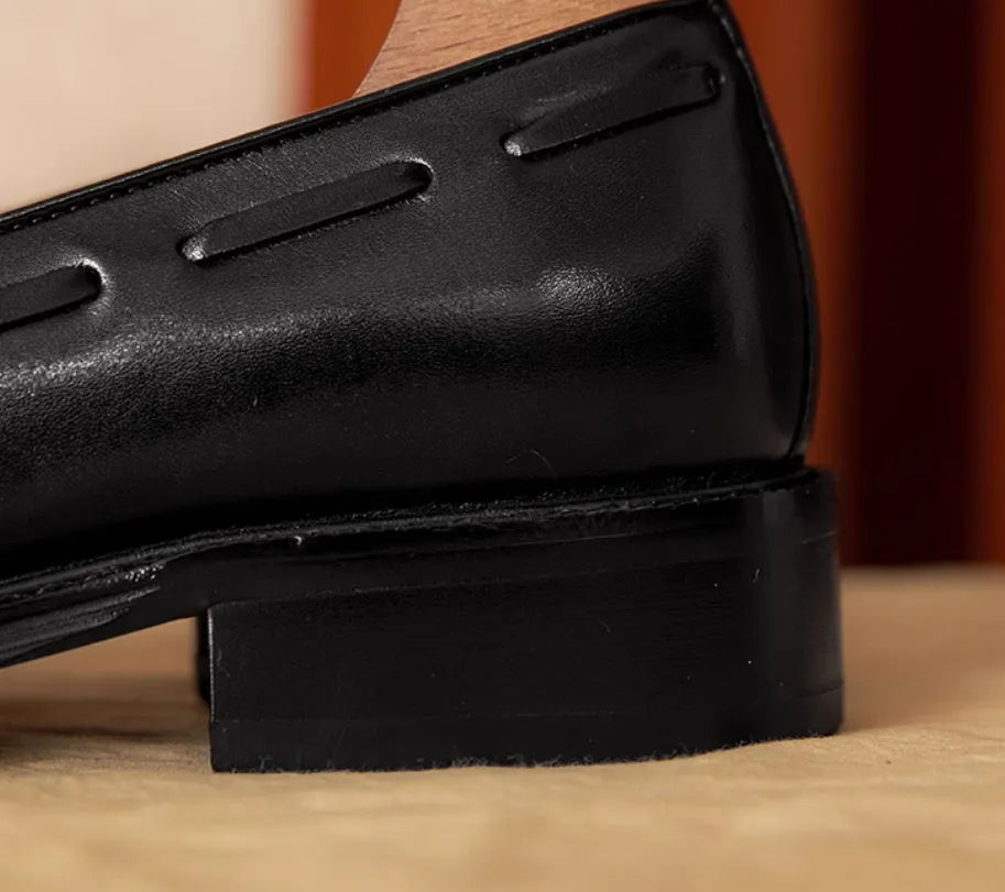 Men's black genuine leather slip-on loafers with a fringed design and rubber sole.