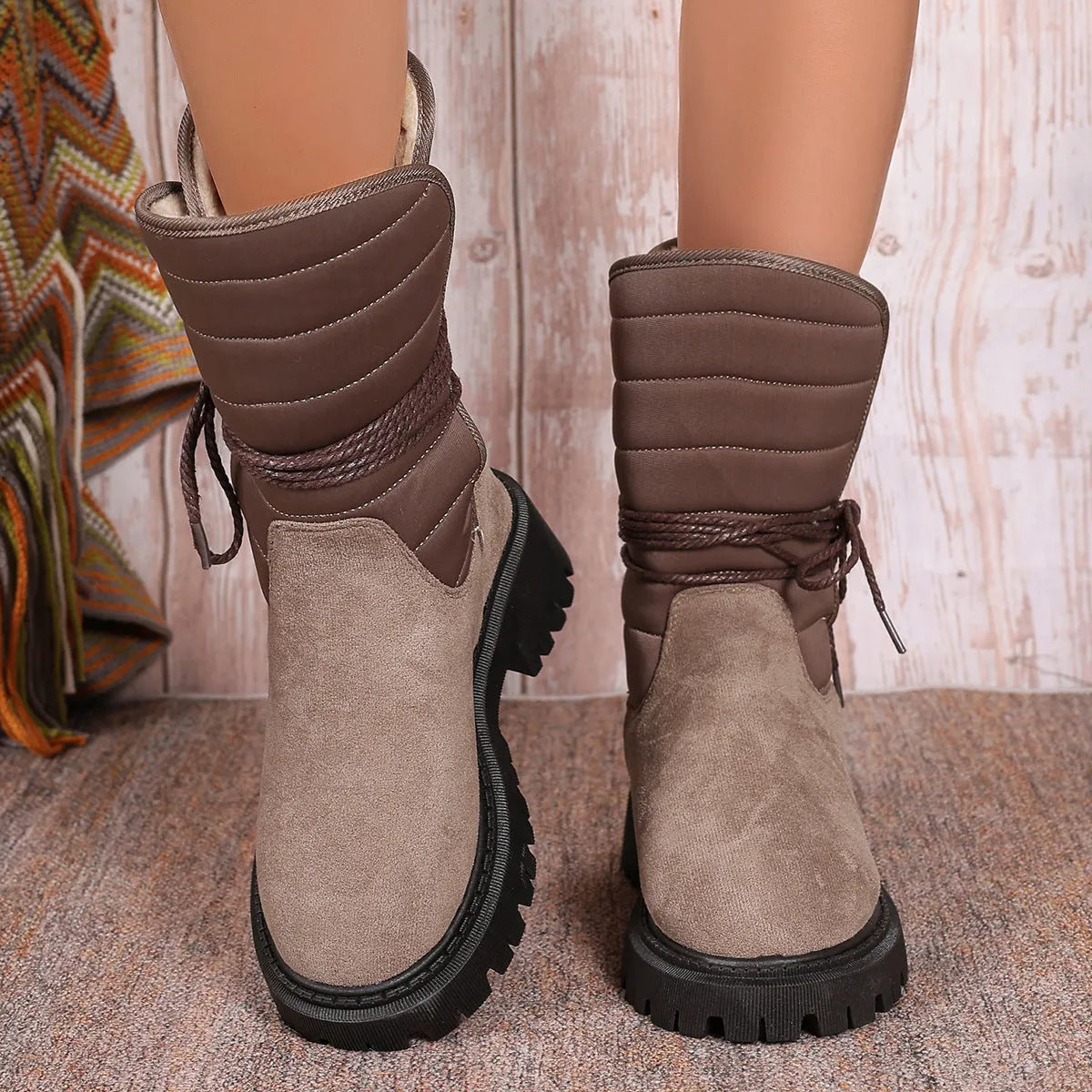 Women's black chunky heel snow boots with suede upper and lace-up design on a white background.