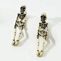 Gold and silver skull detachable stud earrings with skeleton design on white background