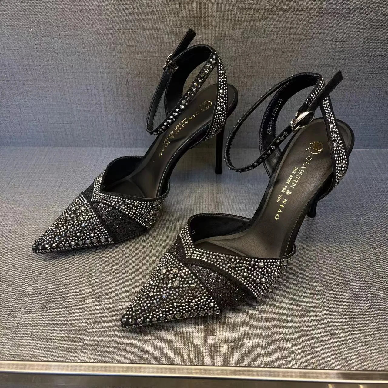Women's black hollow stiletto heel pumps with a red sole and pointed toe.
