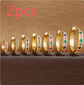 Circle-shaped zircon stud earrings in gold, rose gold, or silver colour on a white background.