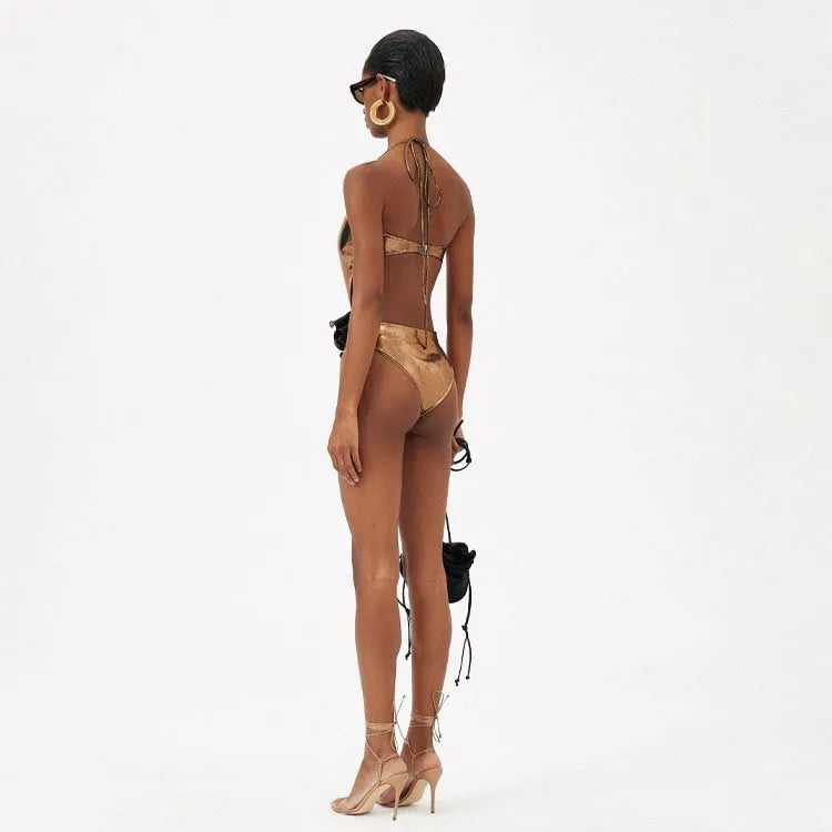 Gold coloured one-piece swimsuit with a halter neck and hollow-out design on a mannequin.