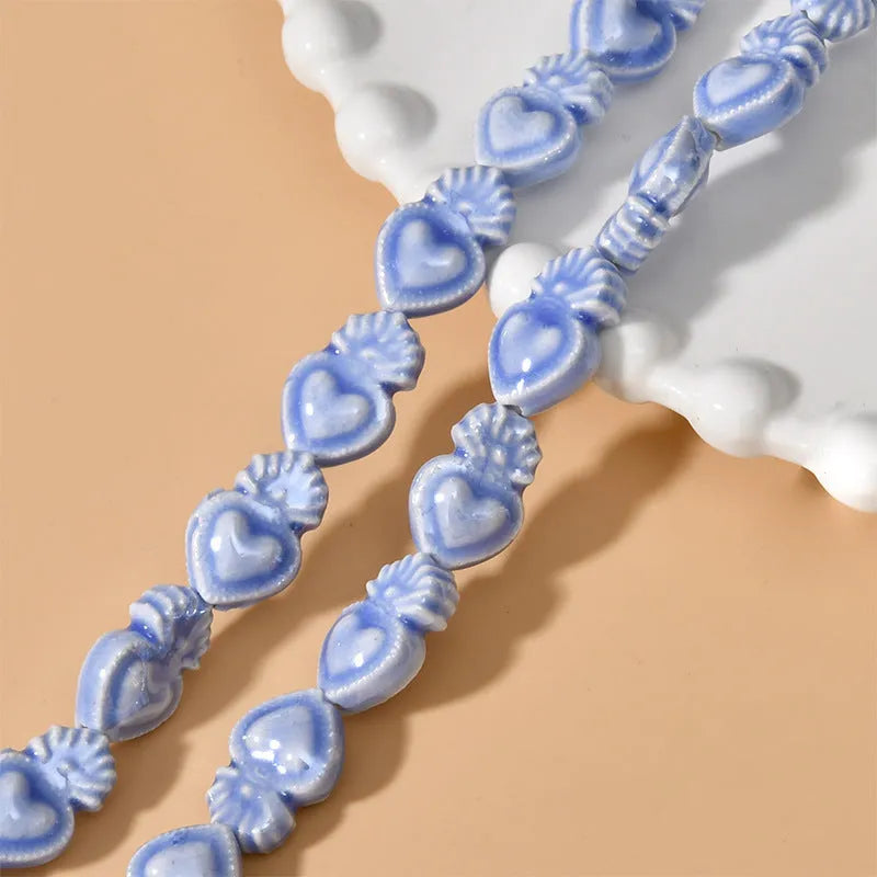 Ceramic love heart torch beads in multiple colours showing 10x15mm size and straight hole design