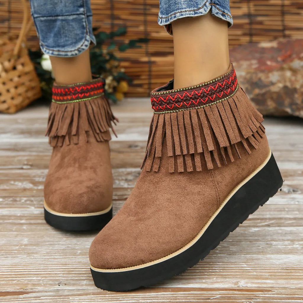 Women's suede ankle booties with a wedge heel, side zipper, tassel detail, and thick rubber sole.