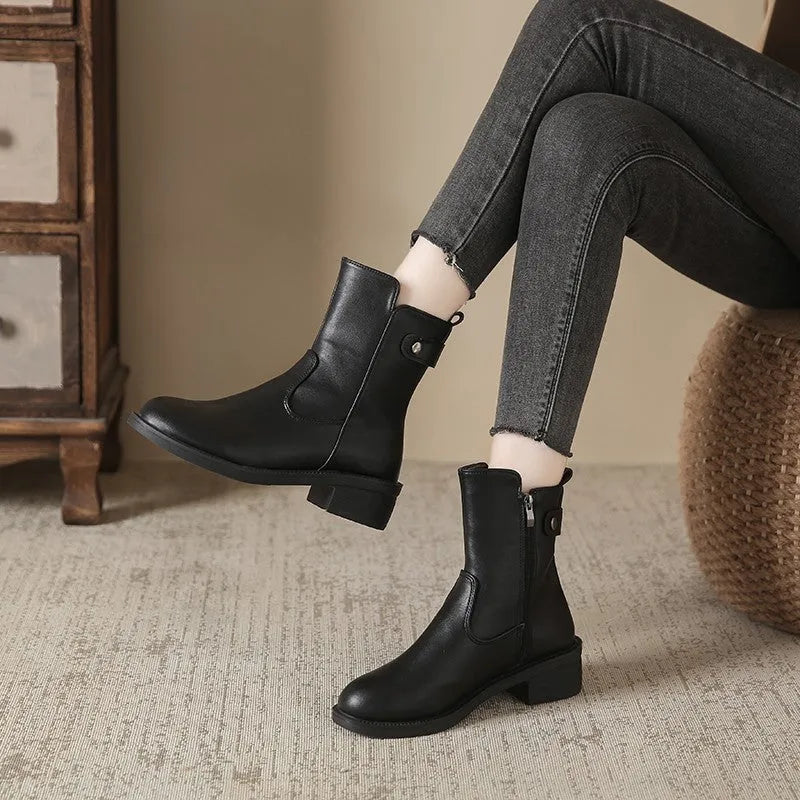 Black women's low heel ankle boots with a side zip and round toe on a rubber sole.