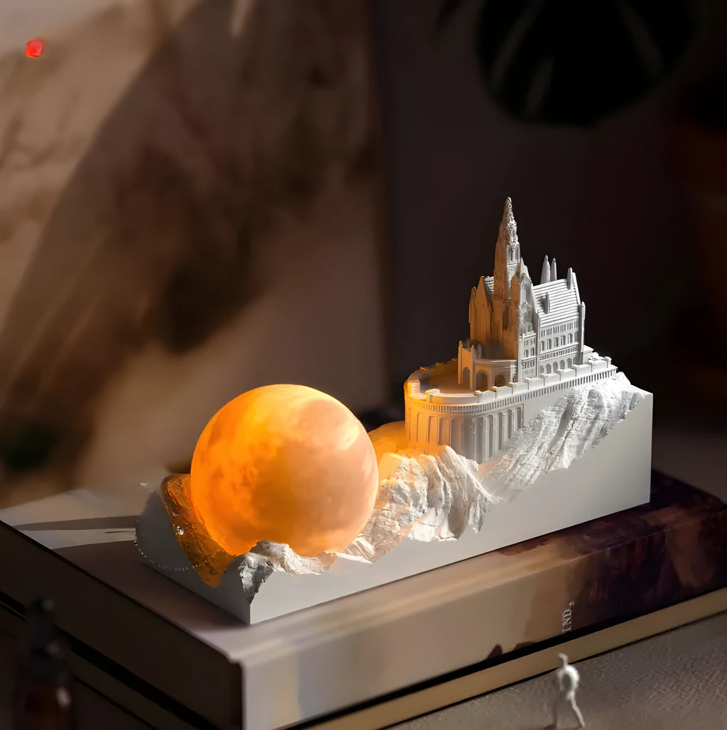 Mountain-shaped night light with LED touch control, essential oil bottle, and gift card on a wooden desk