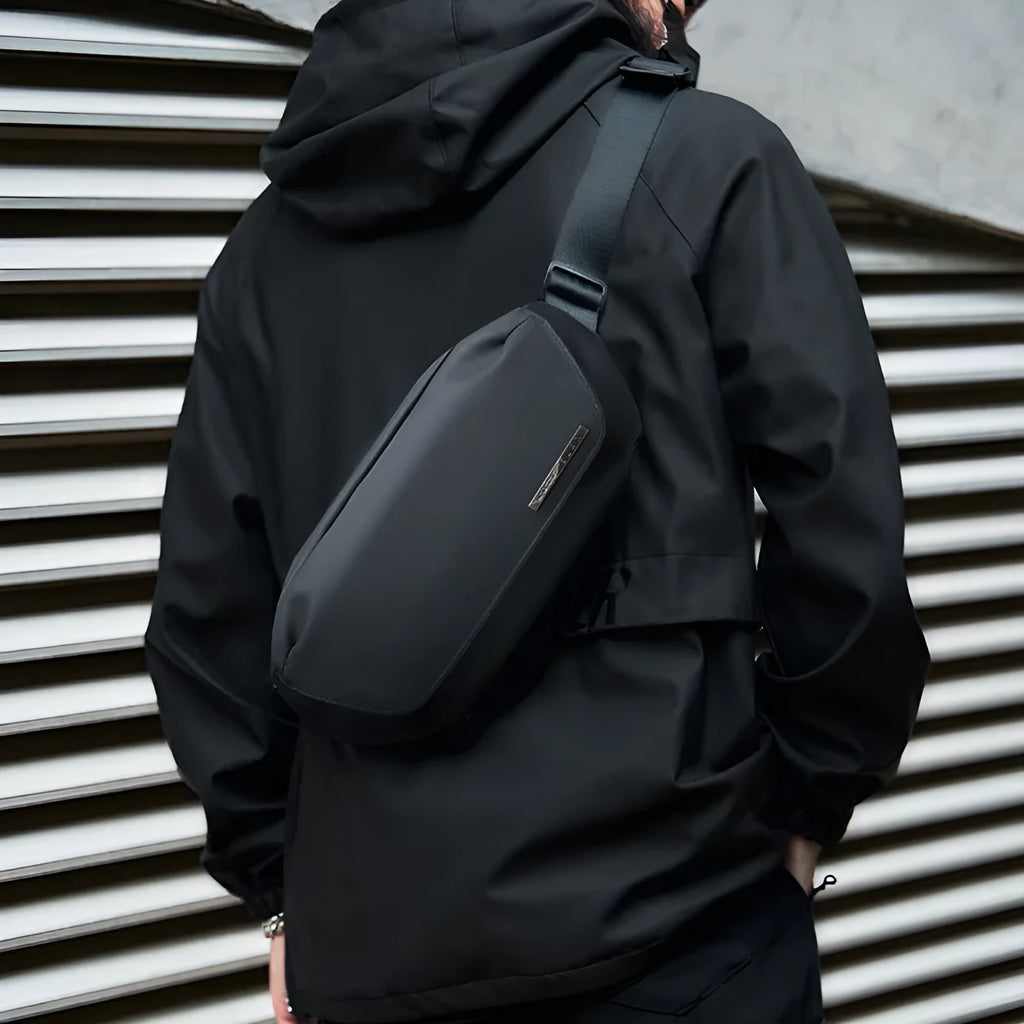 Black men's messenger bag made from Oxford cloth with a one-shoulder strap and street style details.