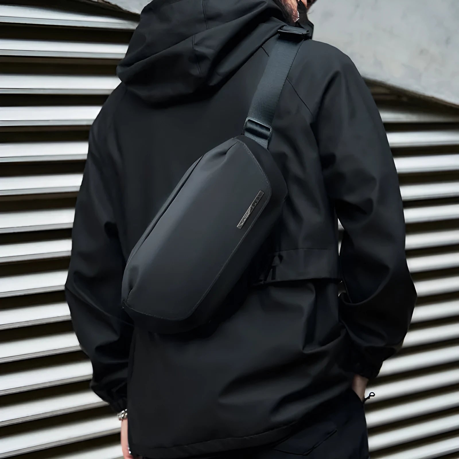 Black men's messenger bag made from Oxford cloth with a one-shoulder strap and street style details.