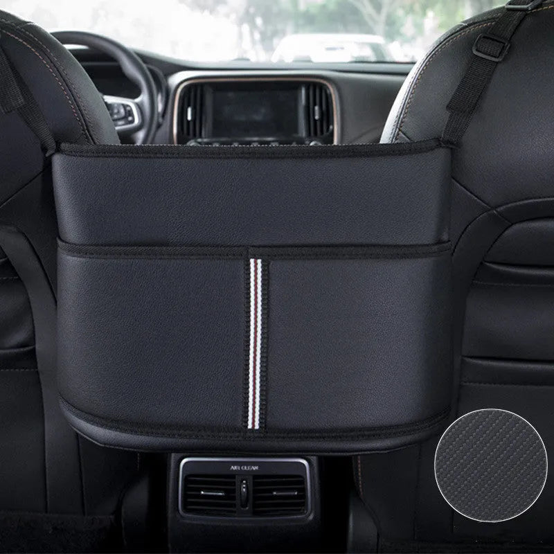 Black leather car seat storage bag with carbon fibre pattern, shown between vehicle front seats.