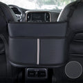 Black leather car seat storage bag with carbon fibre pattern, shown between vehicle front seats.
