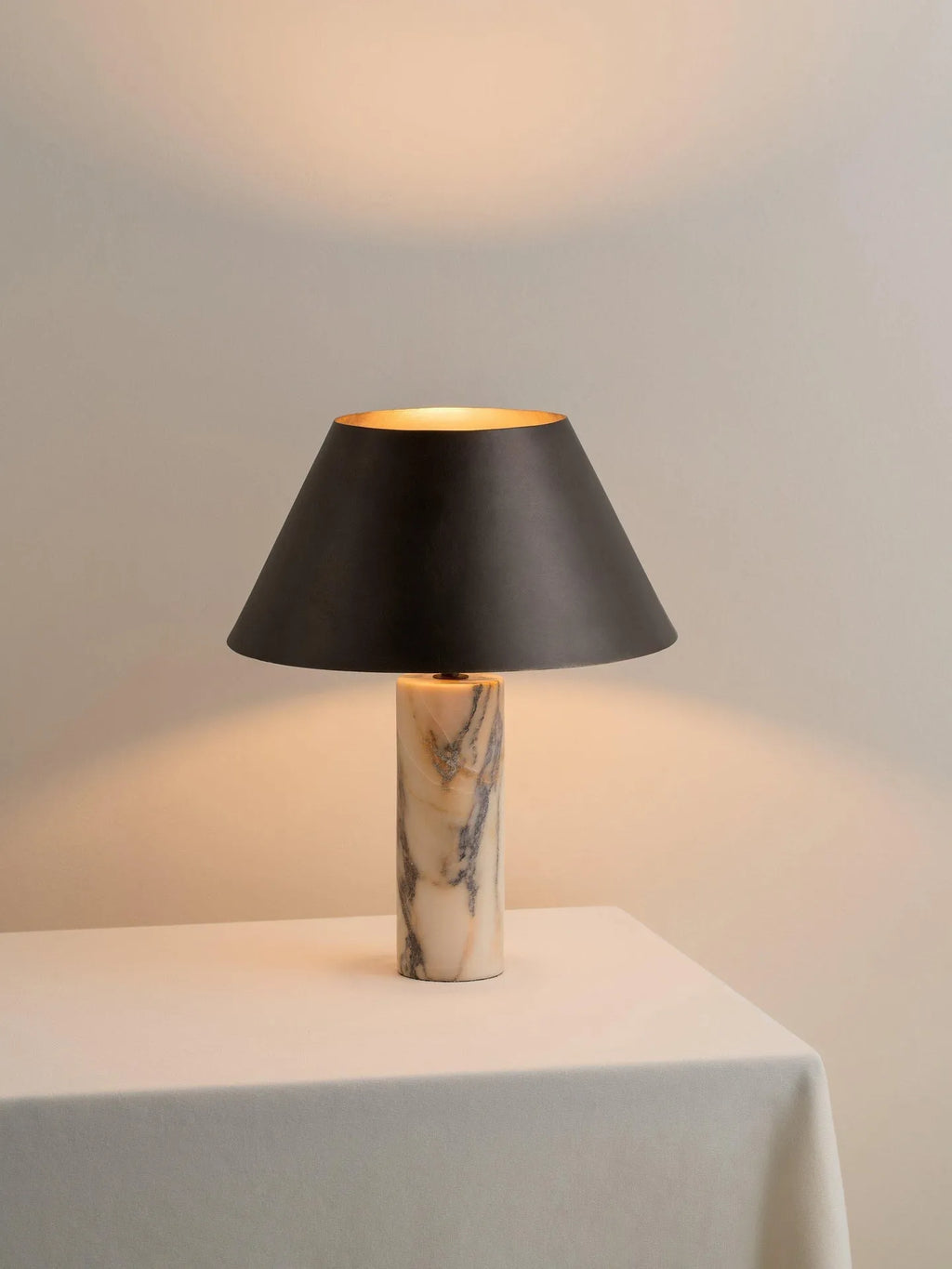Modern black shade table lamp with marble base on wooden surface