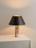 Modern black shade table lamp with marble base on wooden surface