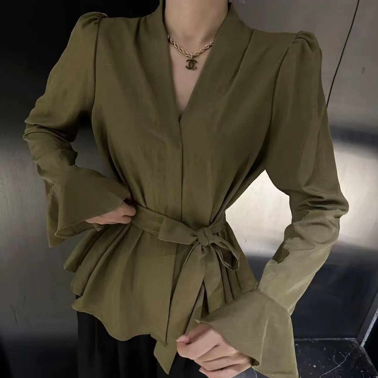 Women's black French-style shirt with irregular collar, long bell sleeves, and tied front detail.