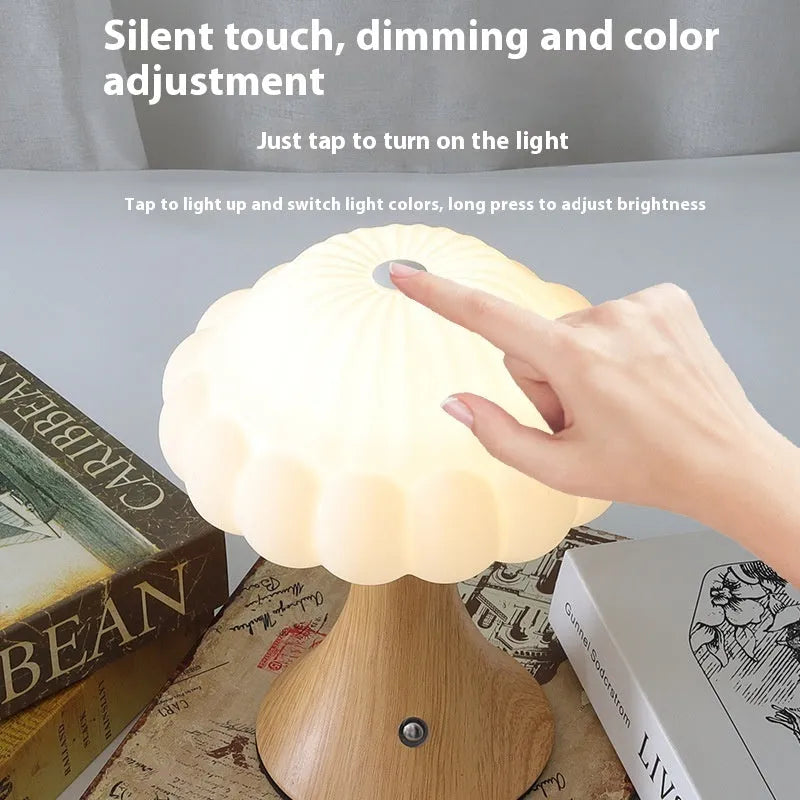 Small decorative mushroom-shaped night lamp on a surface, showcasing its USB charging port and touch control.