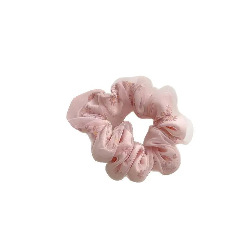 Mesh sense polyester large intestine hair band in milky white, pink, and light blue on a plain background
