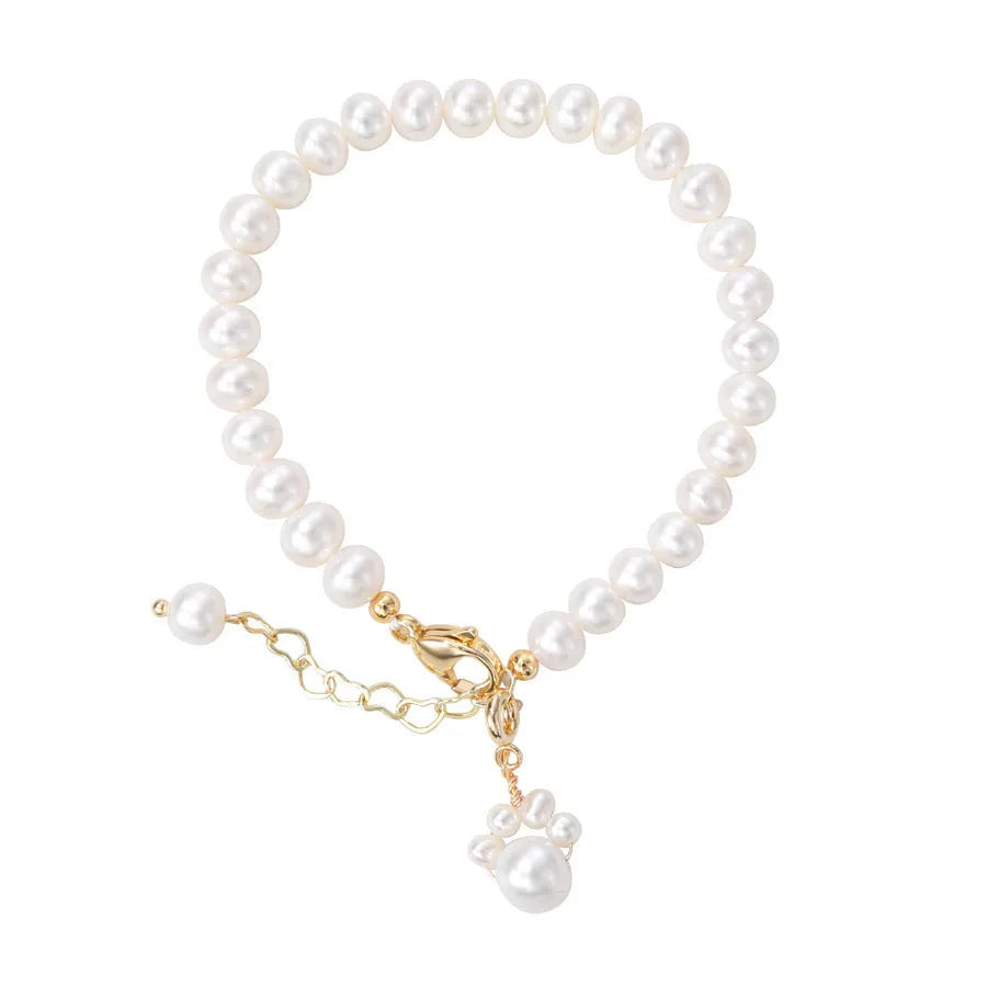 Women's white freshwater pearl cat's paw bracelet with electroplating finish on a neutral background