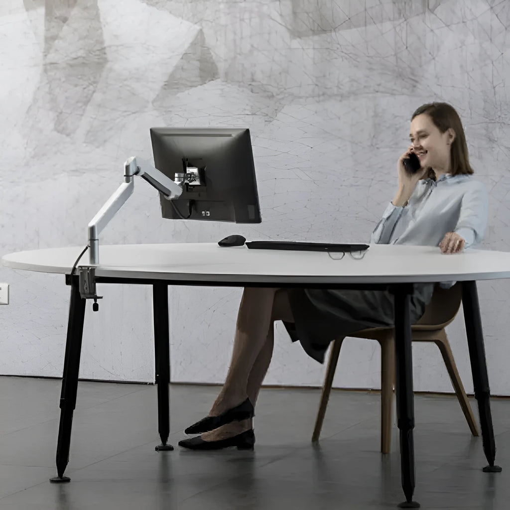Silver aluminium alloy Free Hover laptop stand with adjustable air pressure arm on a desk.