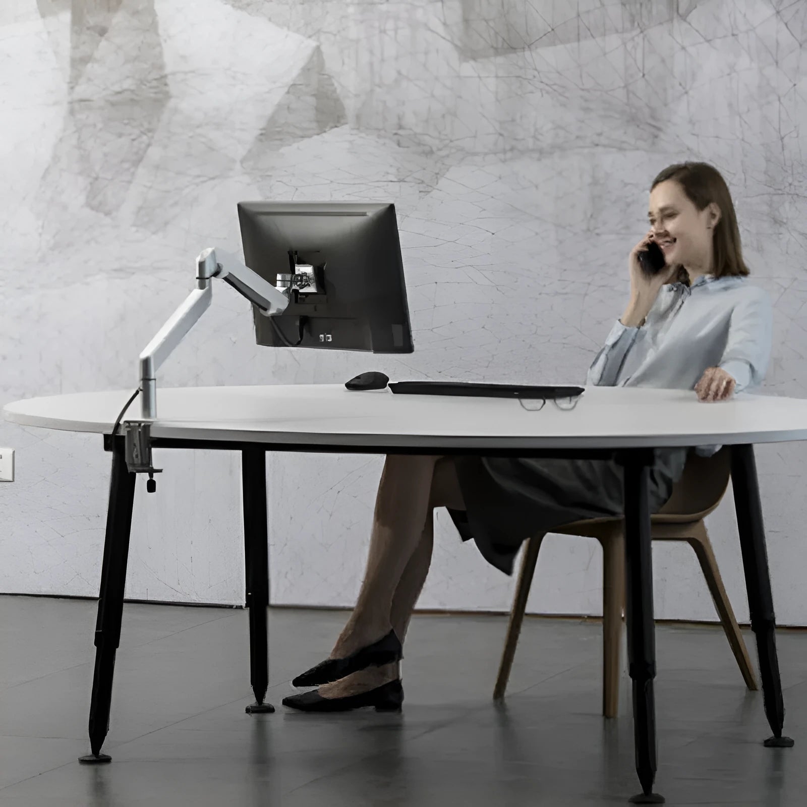 Silver aluminium alloy Free Hover laptop stand with adjustable air pressure arm on a desk.