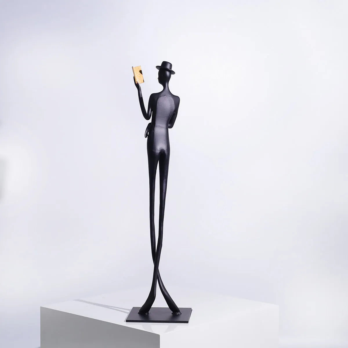 Black aluminium sculpture of reading woman for desktop decoration measuring 51cm tall