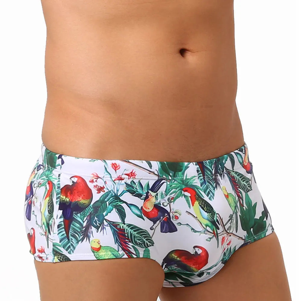 Men's navy blue swimming trunks with colourful flower and bird print pattern.