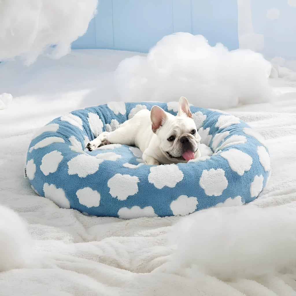 Round plaid dog bed with plastic base on a wooden floor