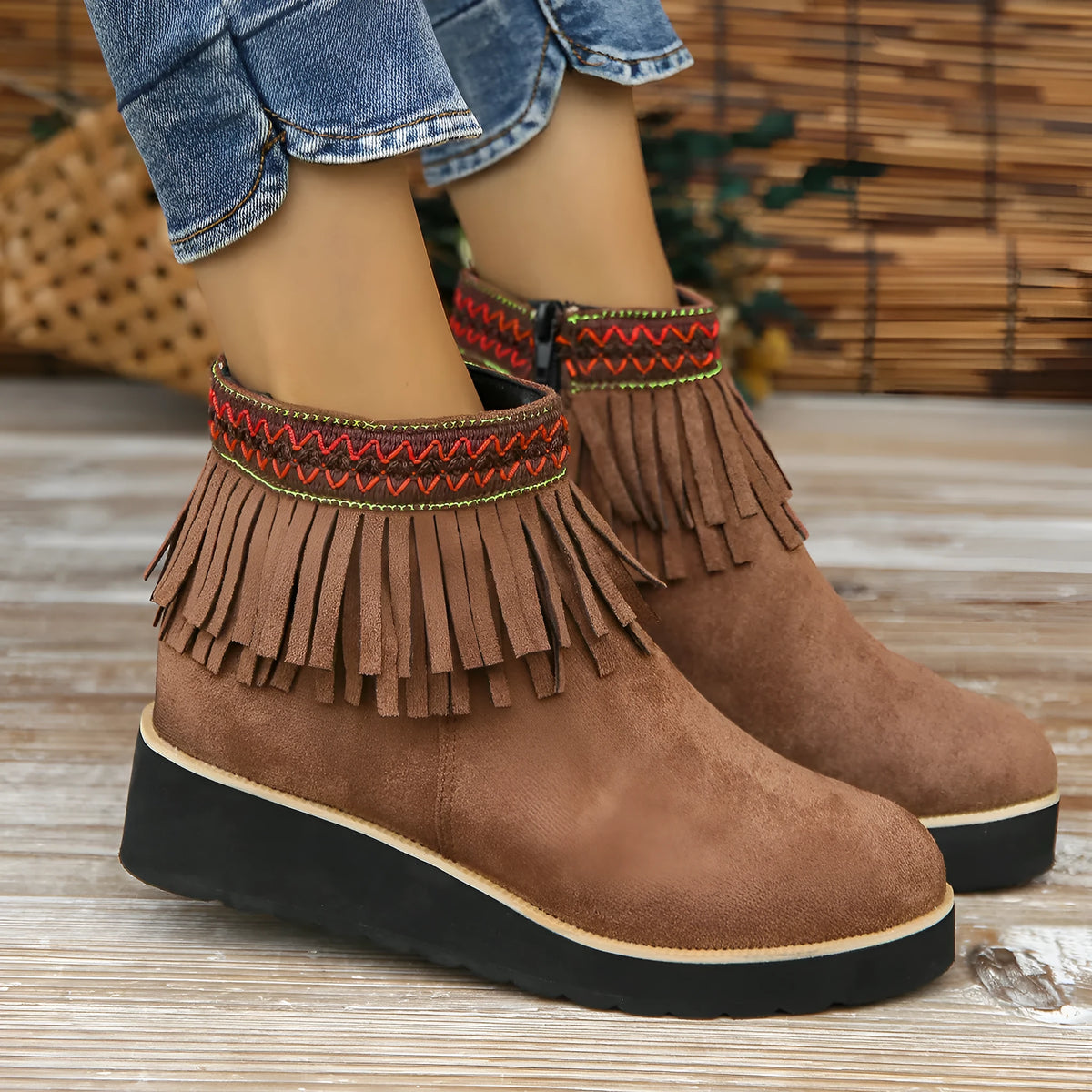 Women's suede ankle booties with a wedge heel, side zipper, tassel detail, and thick rubber sole.