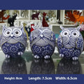 Three blue and white owl resin ornaments in large and small sizes on a white shelf