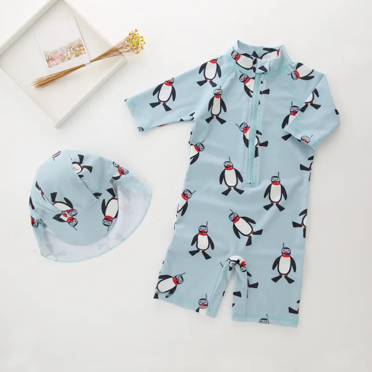 Boys' long sleeve penguin print swimsuit and matching swim cap set on a white background.