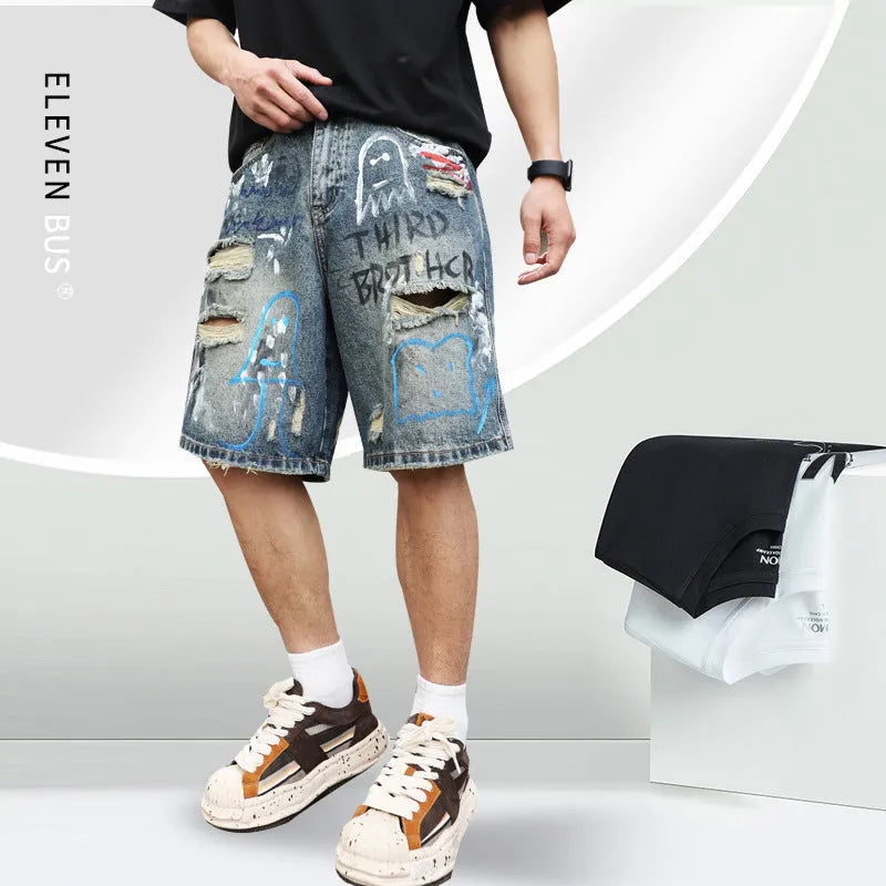 Blue ripped men's denim shorts with graffiti design, showing straight leg and zipper fly.