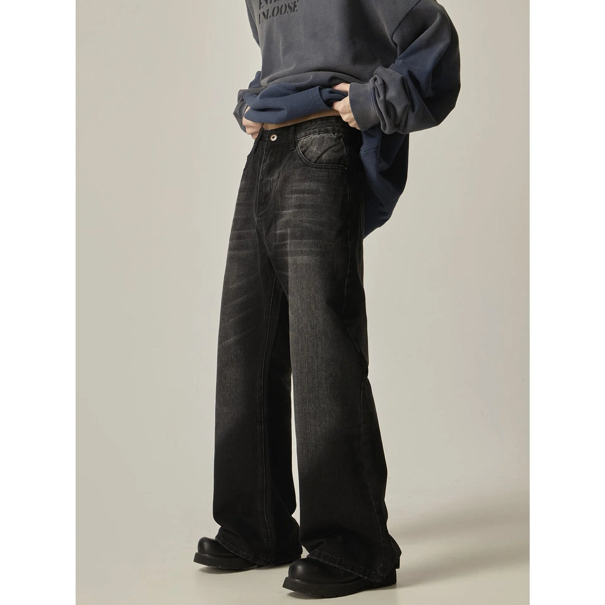Black loose-fit straight leg denim jeans on a mannequin, showing the zip fly and retro style.