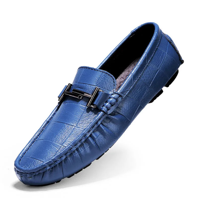 Men's brown leather slip-on loafers with a silver belt buckle detail on the front.