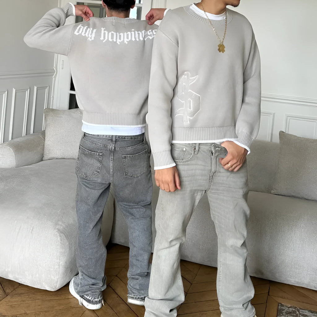 Grey loose-fitting jacquard knitwear coat with long sleeves on a hanger.